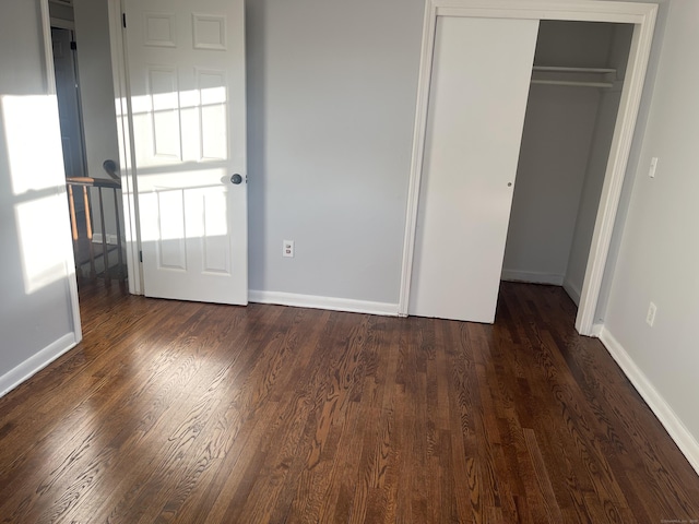 unfurnished bedroom featuring dark hardwood / wood-style flooring and a closet