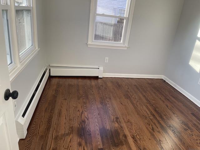 spare room featuring dark hardwood / wood-style floors and a baseboard heating unit