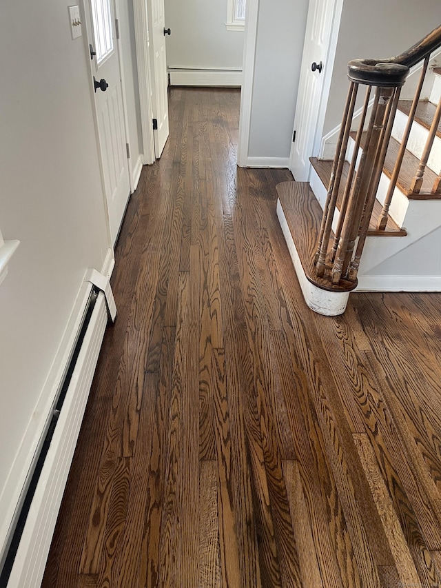 hall with dark hardwood / wood-style flooring and a baseboard heating unit