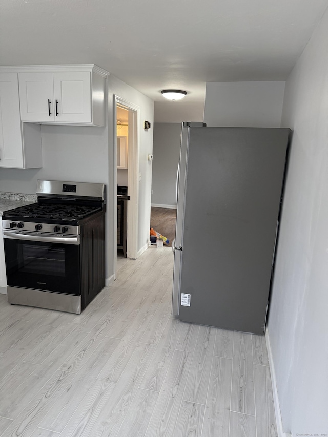 kitchen with white cabinetry, light hardwood / wood-style flooring, and appliances with stainless steel finishes