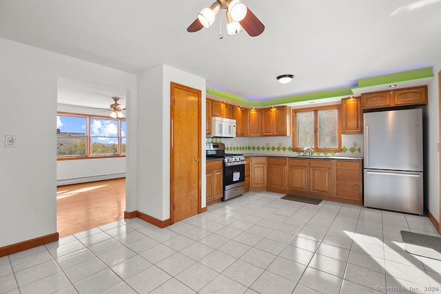 kitchen featuring sink, backsplash, ceiling fan, stainless steel appliances, and light tile patterned floors