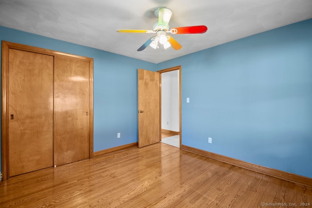 unfurnished bedroom featuring a closet, light wood-type flooring, and ceiling fan