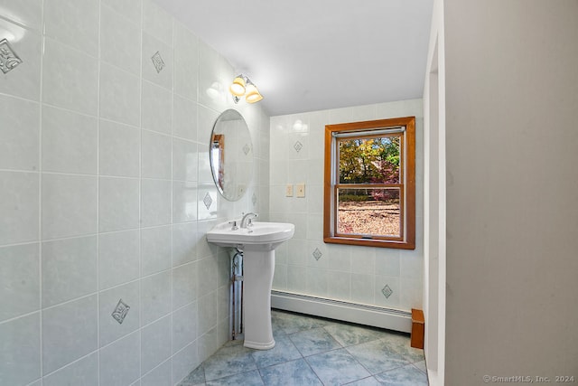 bathroom with baseboard heating, sink, tile walls, and tile patterned flooring