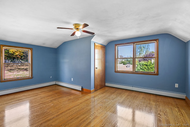 additional living space with baseboard heating, ceiling fan, light wood-type flooring, and vaulted ceiling