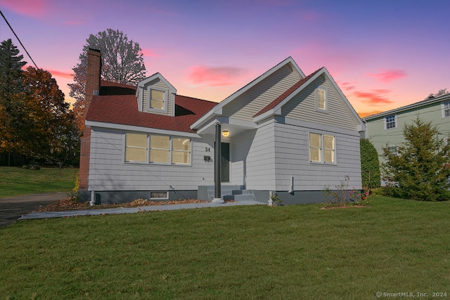 cape cod home with a lawn