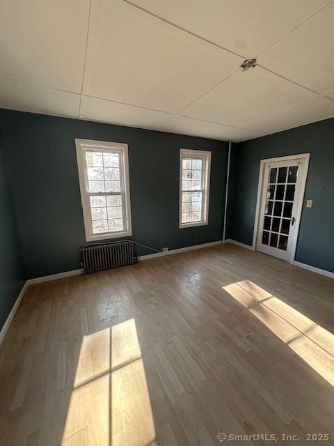 unfurnished room with wood-type flooring and radiator