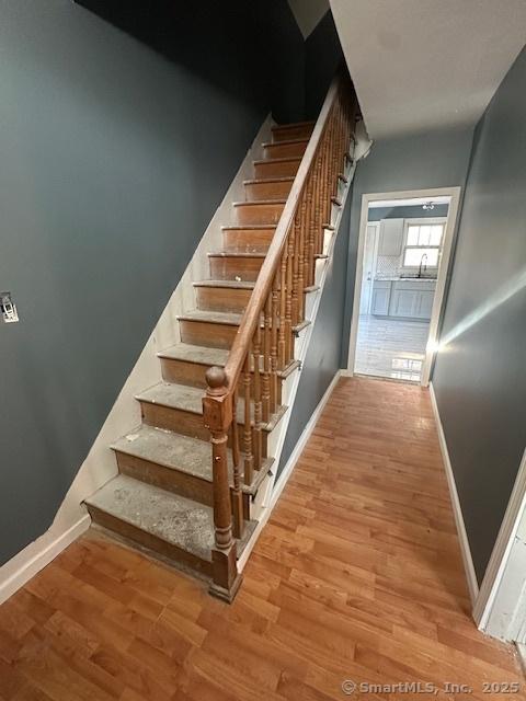 stairway featuring sink and hardwood / wood-style flooring