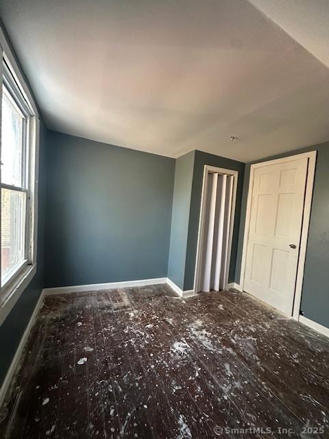 unfurnished bedroom featuring multiple windows