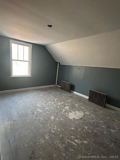 additional living space with lofted ceiling and radiator