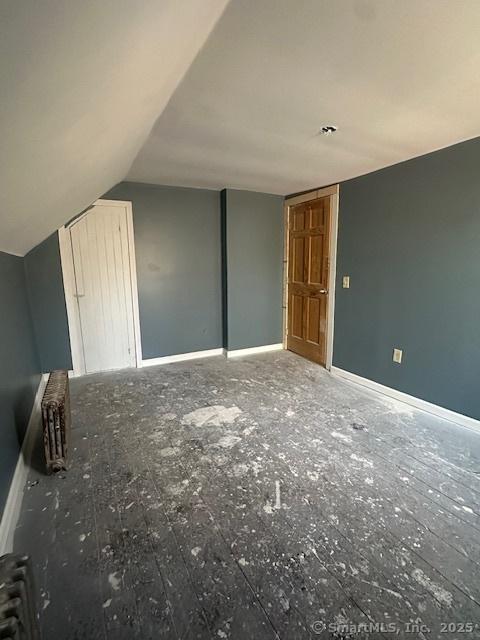 bonus room featuring radiator and vaulted ceiling