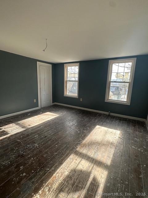 unfurnished room with dark hardwood / wood-style flooring