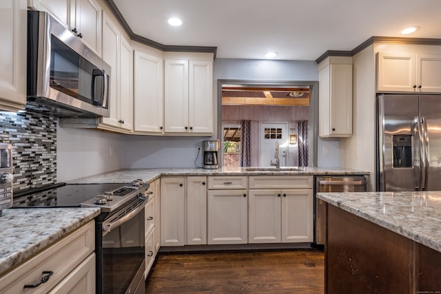 kitchen featuring backsplash, sink, light stone countertops, appliances with stainless steel finishes, and dark hardwood / wood-style flooring