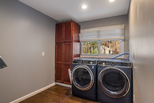 laundry area with cabinets, dark hardwood / wood-style floors, and washing machine and clothes dryer