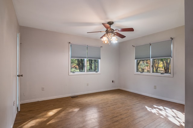 empty room featuring ceiling fan and dark hardwood / wood-style flooring