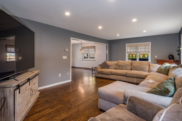 living room featuring a notable chandelier and dark hardwood / wood-style floors