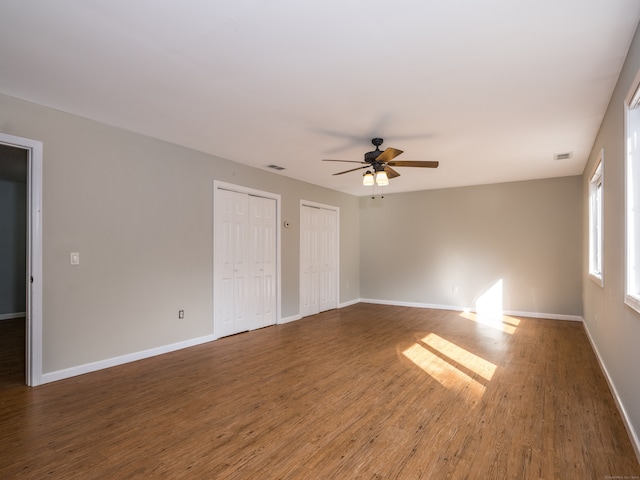 empty room with ceiling fan and dark hardwood / wood-style flooring