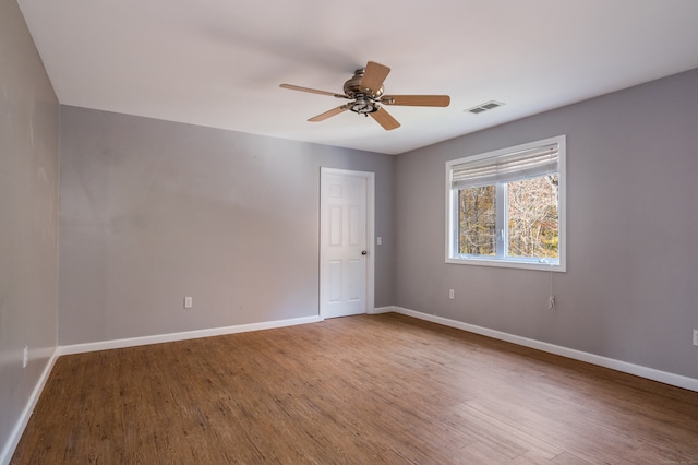 empty room with hardwood / wood-style floors and ceiling fan