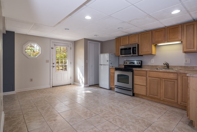 kitchen with light tile patterned flooring, stainless steel appliances, and sink