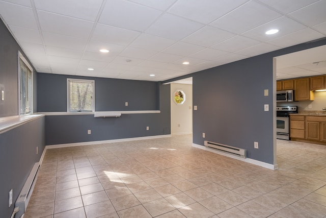 interior space featuring baseboard heating, sink, and a paneled ceiling