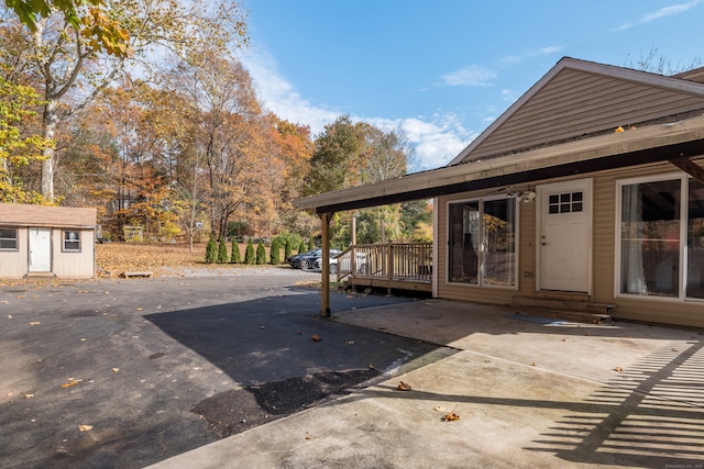 exterior space featuring a patio, a shed, and a deck