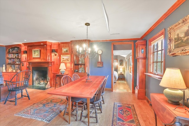 dining room featuring light hardwood / wood-style floors, ornamental molding, and a chandelier