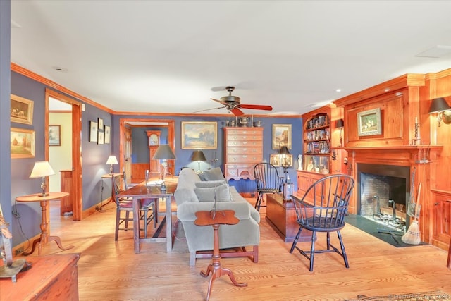 living room featuring ceiling fan, ornamental molding, and light hardwood / wood-style flooring