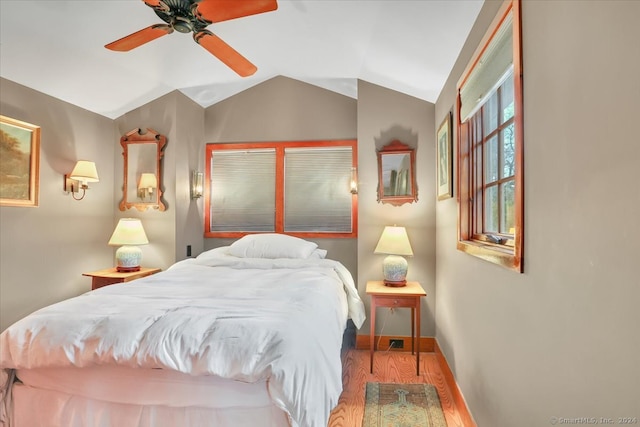 bedroom featuring wood-type flooring, vaulted ceiling, and ceiling fan