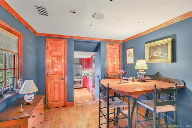 dining space with light hardwood / wood-style floors and ornamental molding