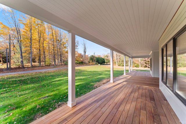 wooden terrace featuring a lawn