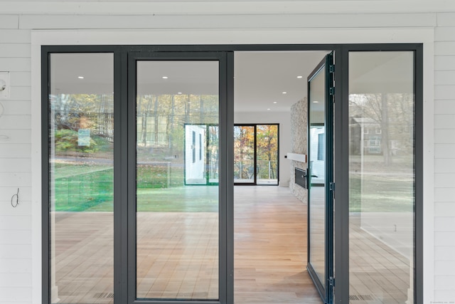 doorway to outside featuring wood walls and light hardwood / wood-style flooring