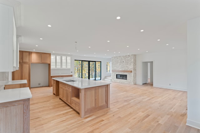 kitchen featuring a large island, a fireplace, and light hardwood / wood-style floors