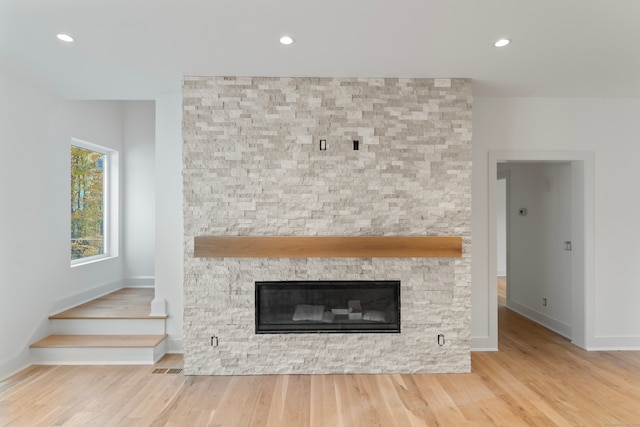 interior details with a stone fireplace and hardwood / wood-style floors