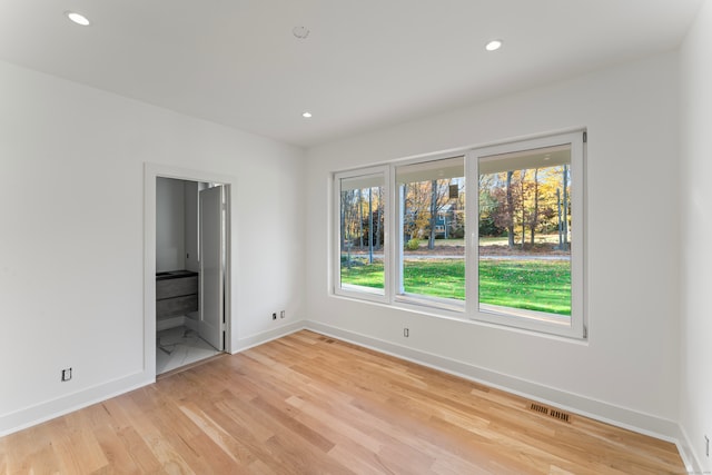 unfurnished bedroom featuring light hardwood / wood-style flooring and connected bathroom