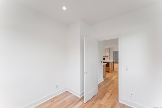 empty room featuring a fireplace and light wood-type flooring