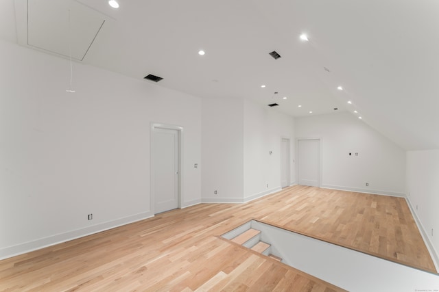 additional living space with vaulted ceiling and light wood-type flooring