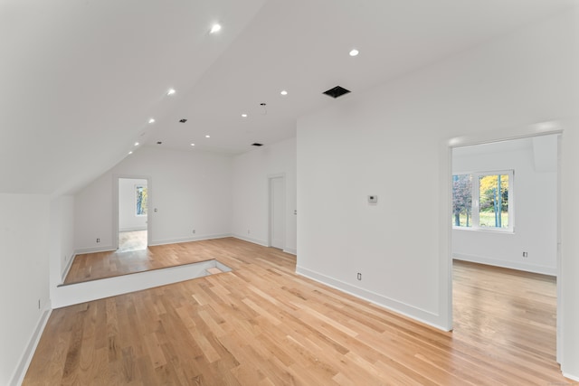 additional living space featuring lofted ceiling and light wood-type flooring