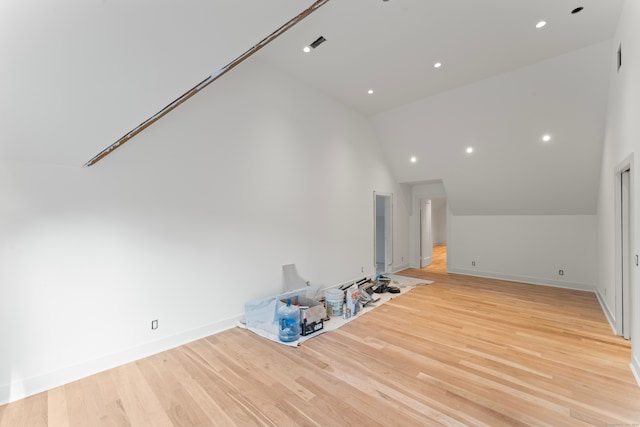 unfurnished living room featuring high vaulted ceiling and light hardwood / wood-style floors