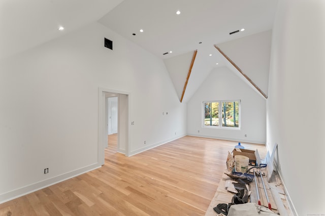 unfurnished living room featuring light hardwood / wood-style floors and high vaulted ceiling