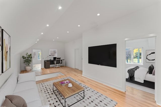 living room with lofted ceiling and light hardwood / wood-style flooring