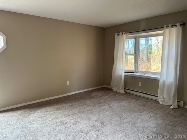 carpeted spare room featuring a baseboard radiator