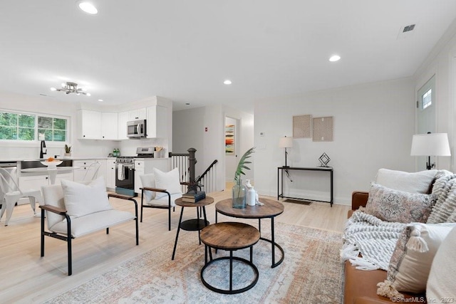 living room with light wood-type flooring and sink