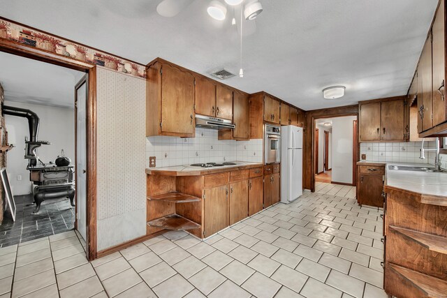 kitchen with light tile patterned floors, sink, white appliances, ceiling fan, and decorative backsplash