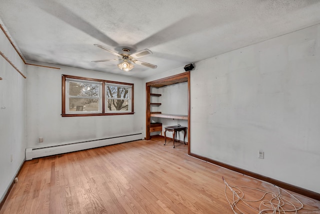 spare room featuring ceiling fan, light hardwood / wood-style flooring, a textured ceiling, and baseboard heating