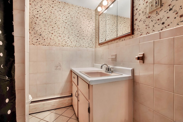 bathroom featuring toilet, tile walls, baseboard heating, vanity, and tile patterned flooring