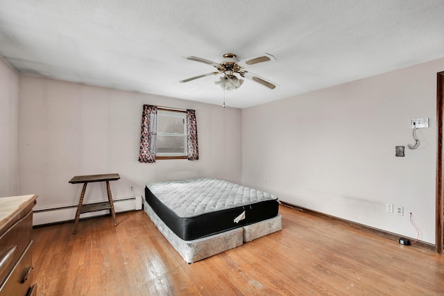 bedroom with wood-type flooring, ceiling fan, a textured ceiling, and baseboard heating