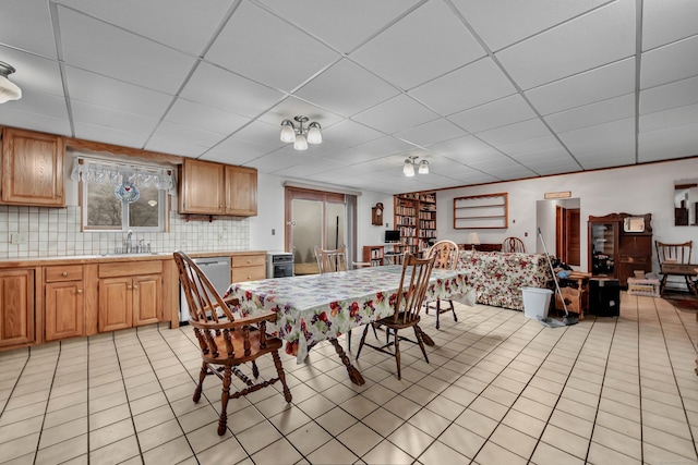 tiled dining room with sink and a paneled ceiling