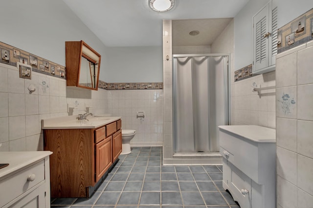 bathroom featuring tile patterned flooring, vanity, tile walls, and an enclosed shower