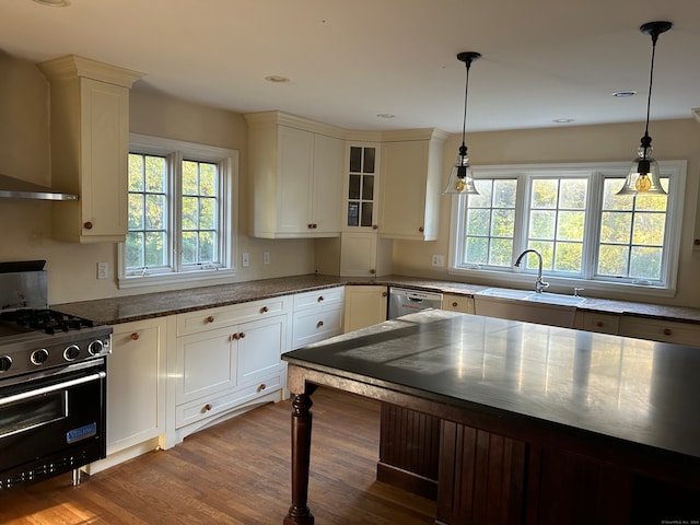 kitchen featuring dark wood-type flooring, wall chimney exhaust hood, decorative light fixtures, and high end range