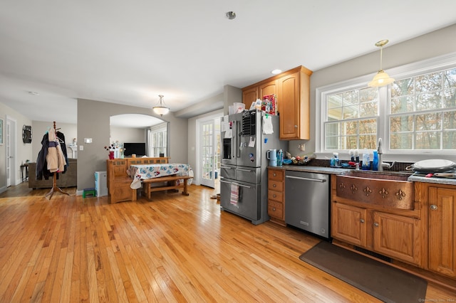 kitchen featuring pendant lighting, stainless steel appliances, and light wood-type flooring