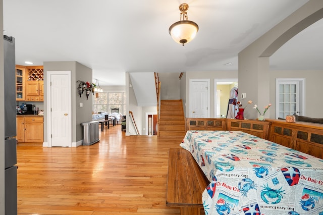 bedroom featuring light wood-type flooring and stainless steel fridge